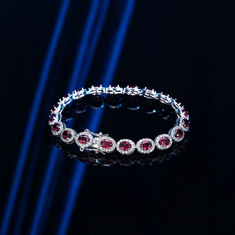 PT950 Platinum Red Corundum Oval Cut Halo Tennis Bracelet with diamond halo setting displayed on dark reflective surface with blue light accents