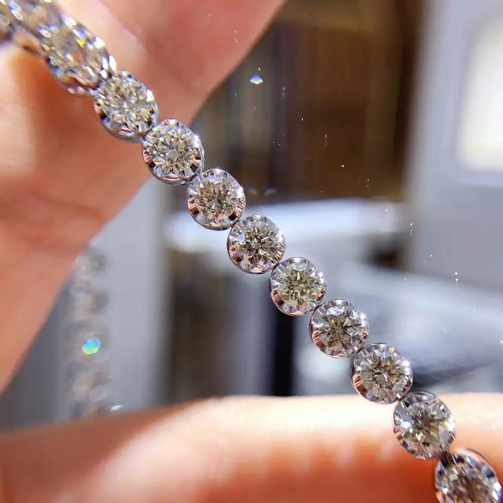 Close-up of a diamond bracelet held by a hand with a blurred background