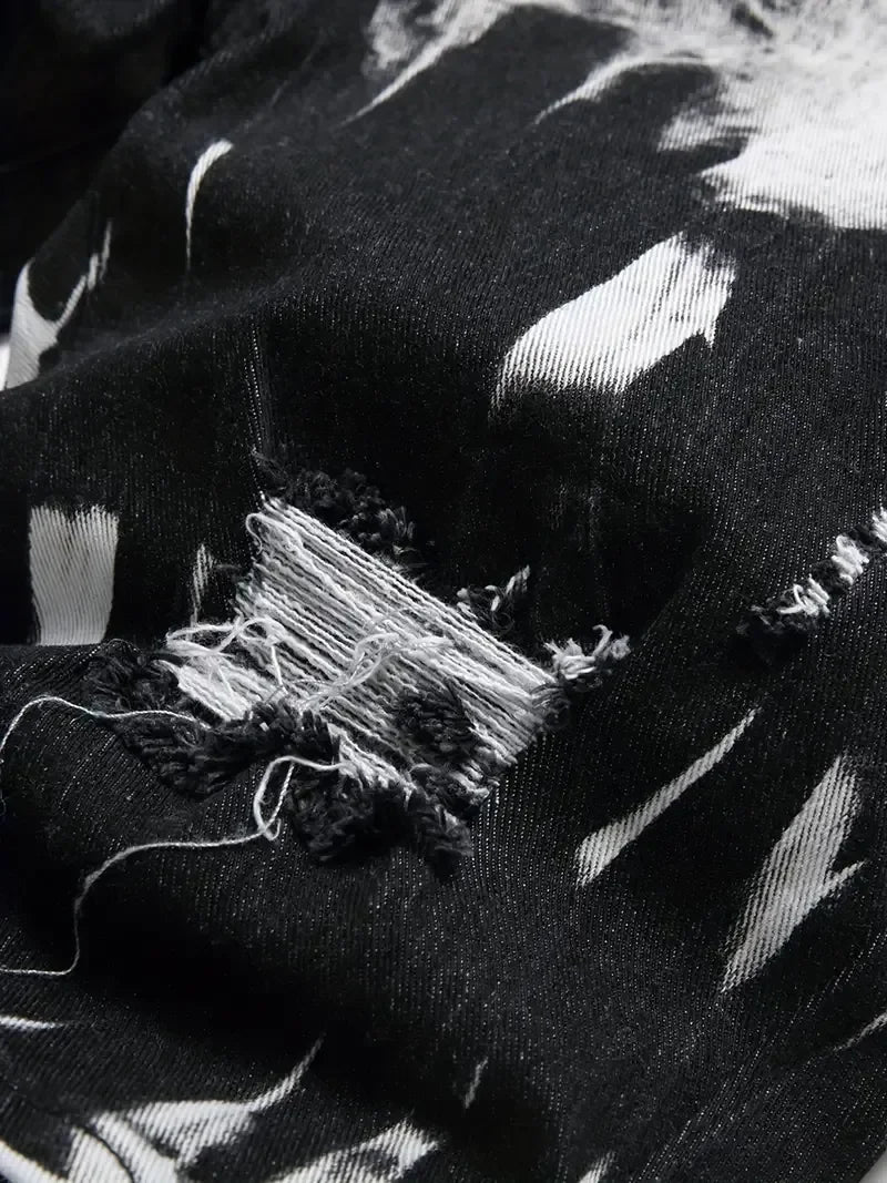 Close-up of a black fabric with white patterns and a tear.