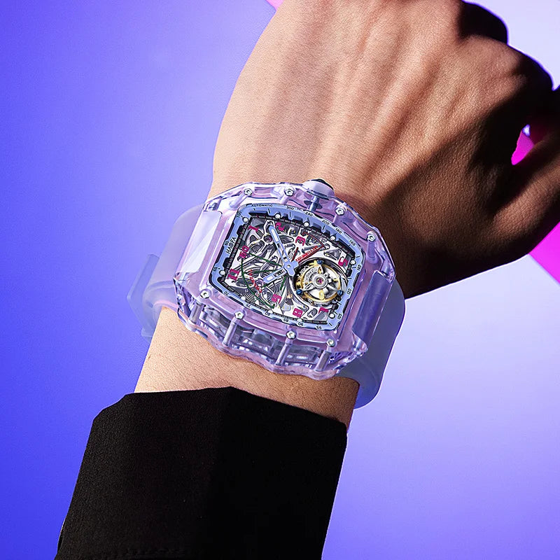 A wristwatch with a translucent lavender-purple case and strap, worn on a person's wrist against a purple gradient background.