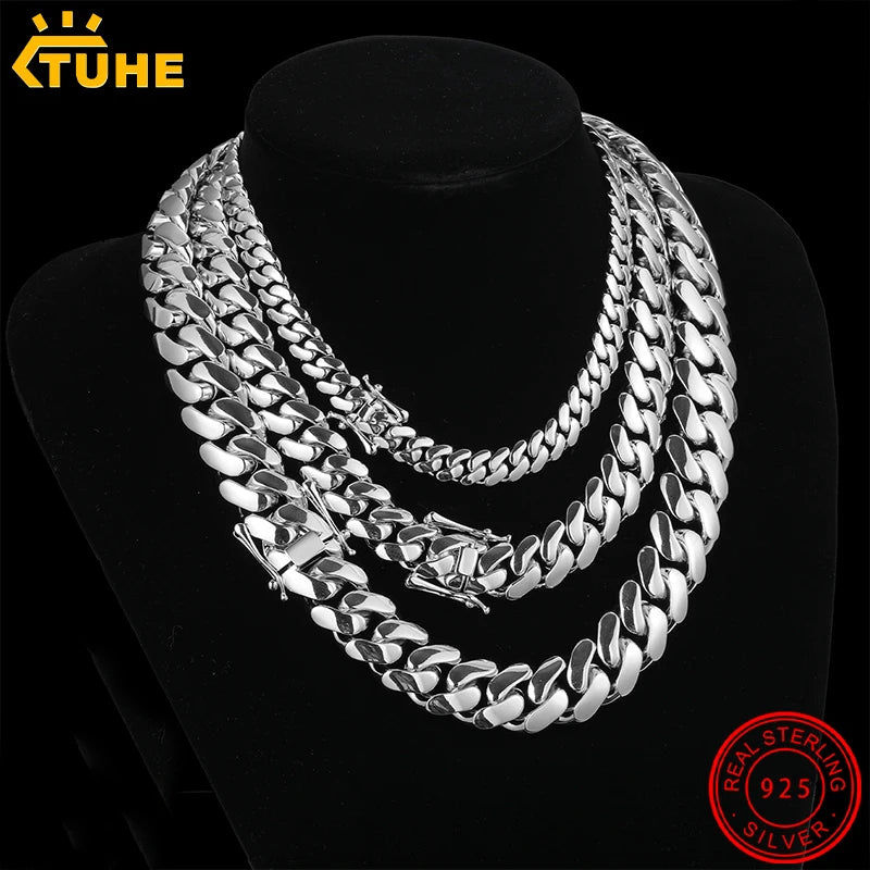 Silver chain necklace on a black stand with 'TUHE' branding and '925' stamp.