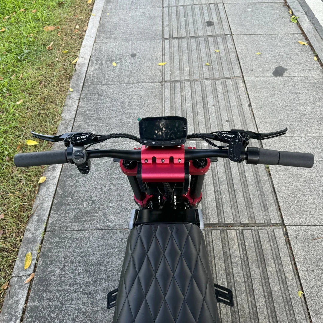 Close-up of a scooter handlebar with red accents on a sidewalk