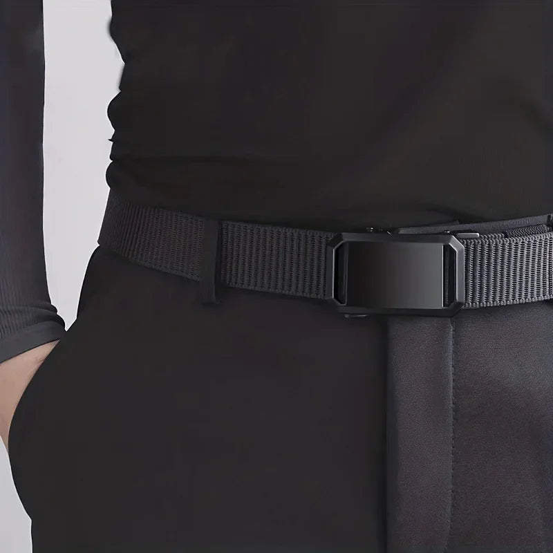 Person wearing a black belt with a large buckle on a plain background
