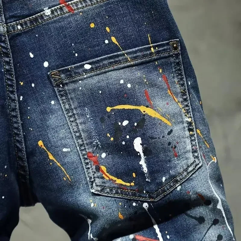 Blue denim pocket with colorful paint splashes on a gray background