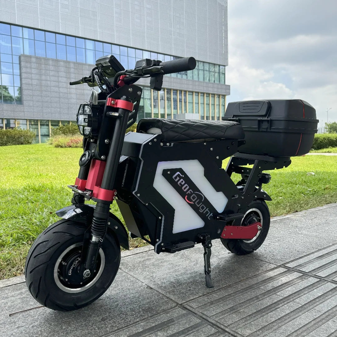 Electric scooter with a black and red design parked on a sidewalk in an urban setting.