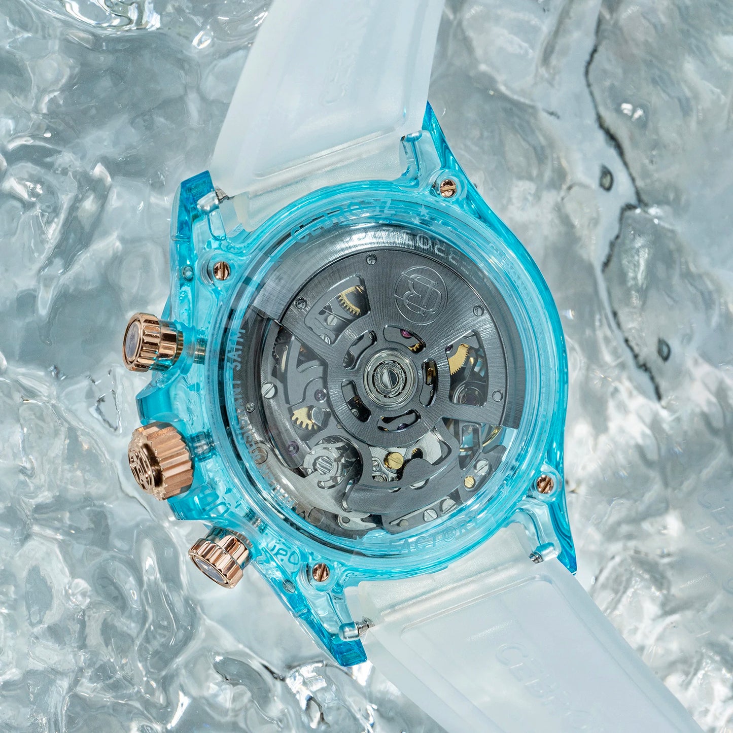 A Casio watch with a translucent light blue case and a frosted white strap, shown from the back with its mechanical movement visible. The watch has rose gold-tone chronograph buttons and is photographed on a textured, icy background.