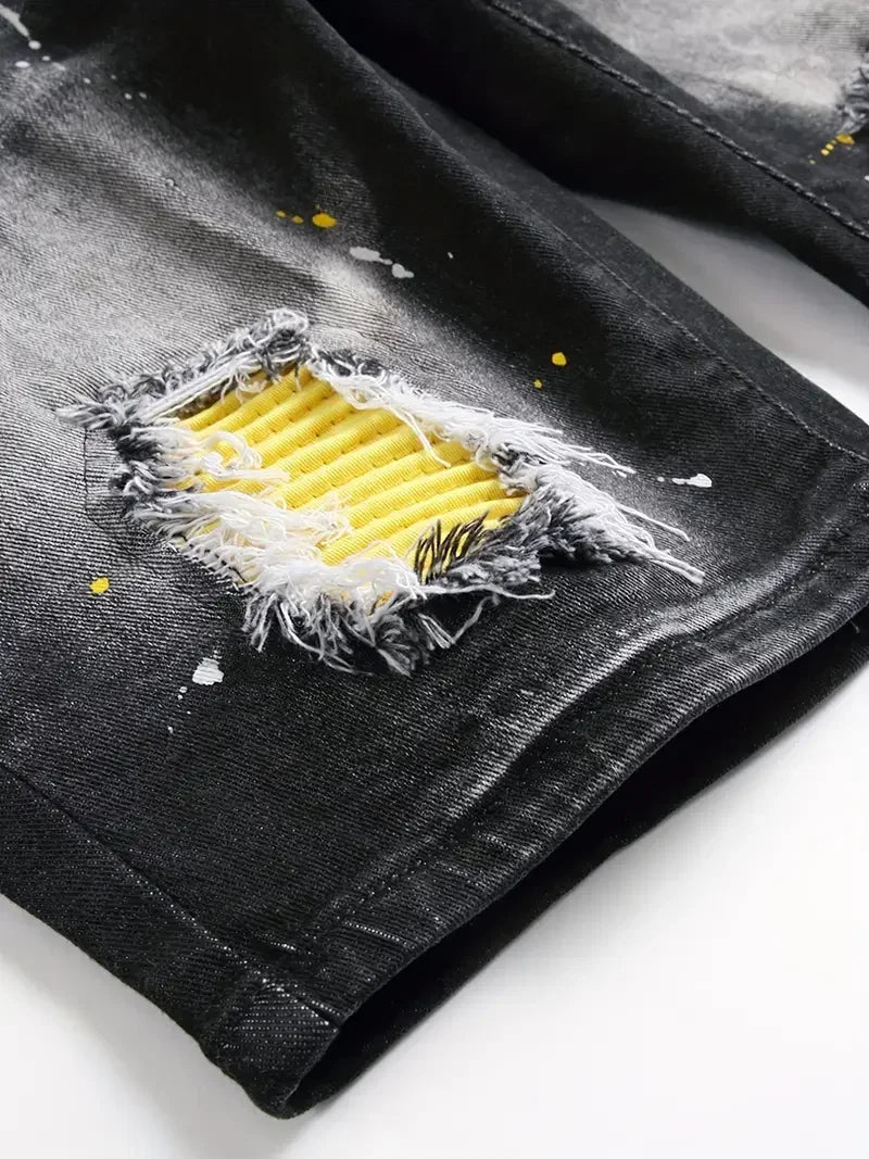 Black denim jacket with a ripped design and yellow interior lining on a white background