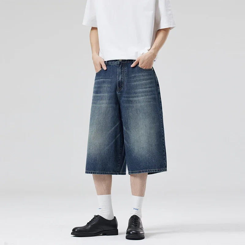 Person wearing blue denim wide-leg shorts on a white background