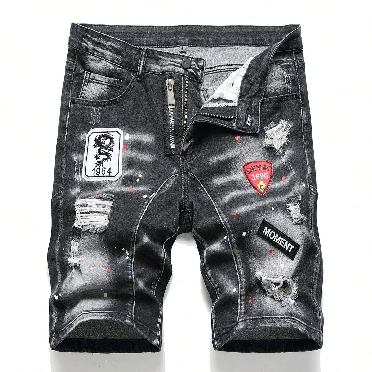 Black distressed denim shorts with patches on a white background