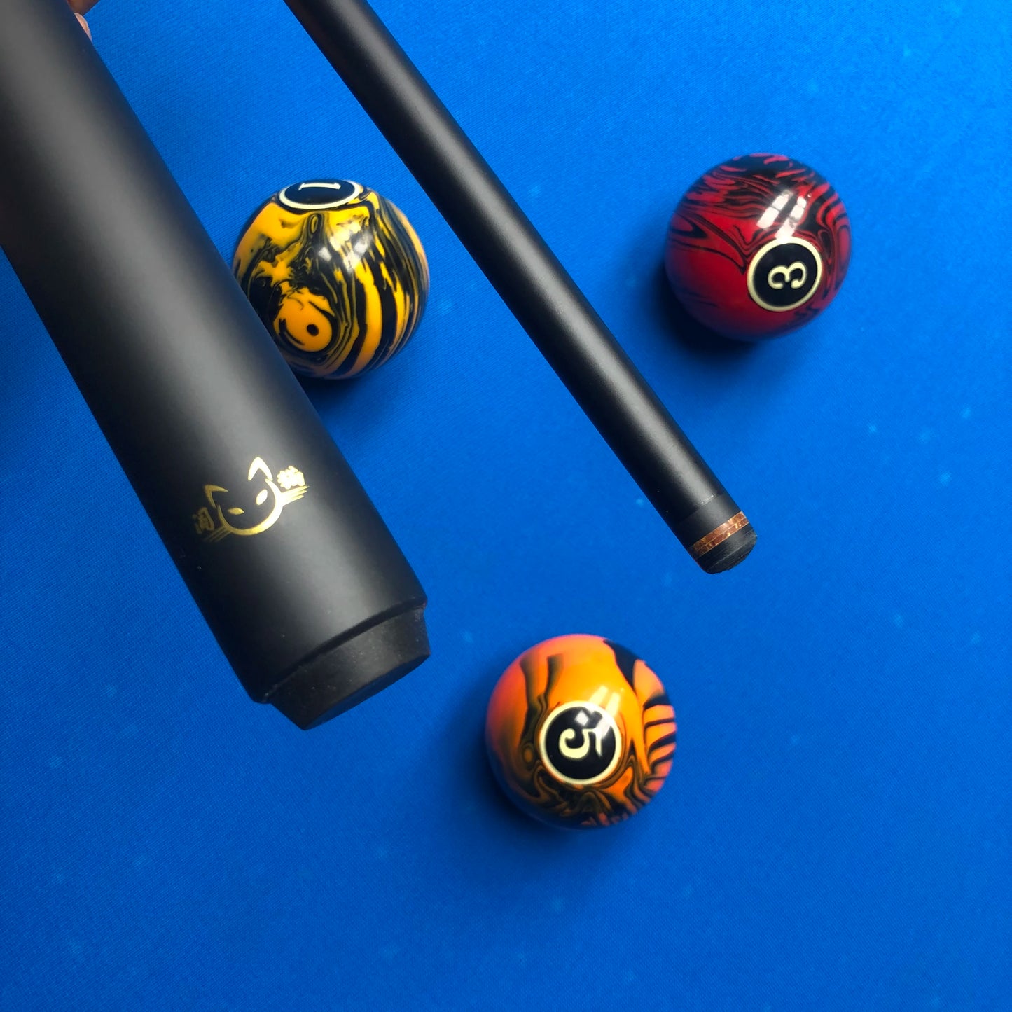 Pool cue and three pool balls with tiger design on a blue background