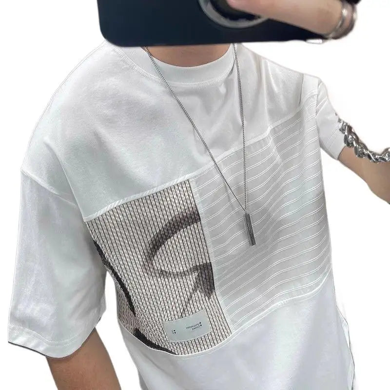 Person wearing a white t-shirt with a mesh panel and a necklace.