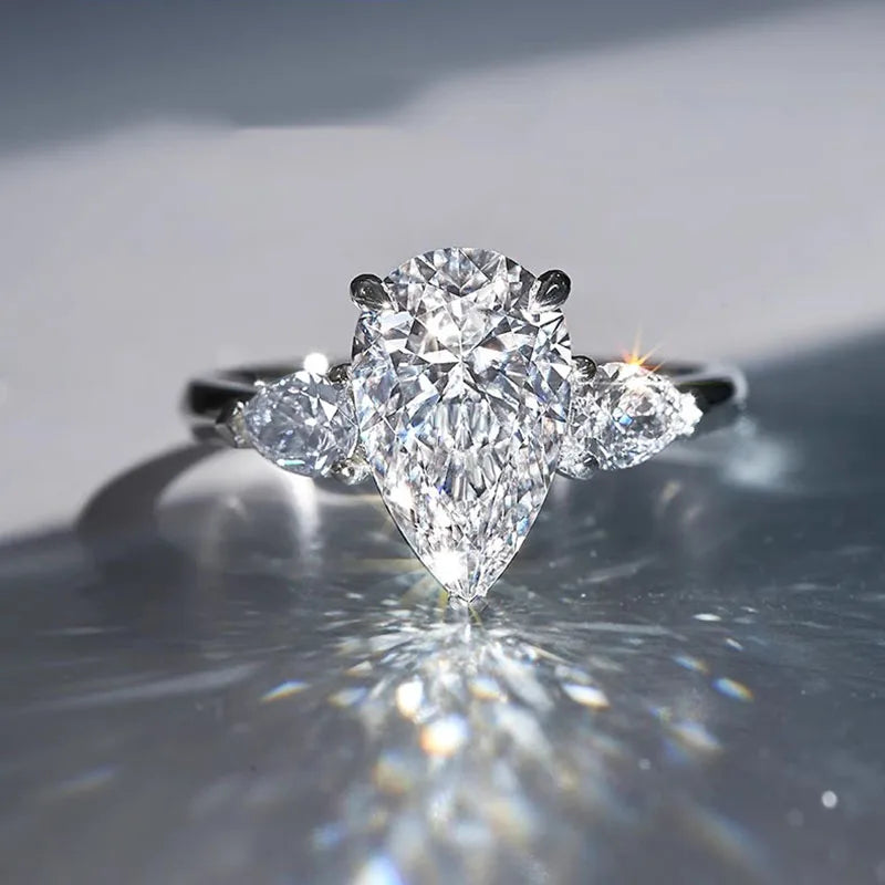 Diamond ring with a heart-shaped center stone on a reflective surface