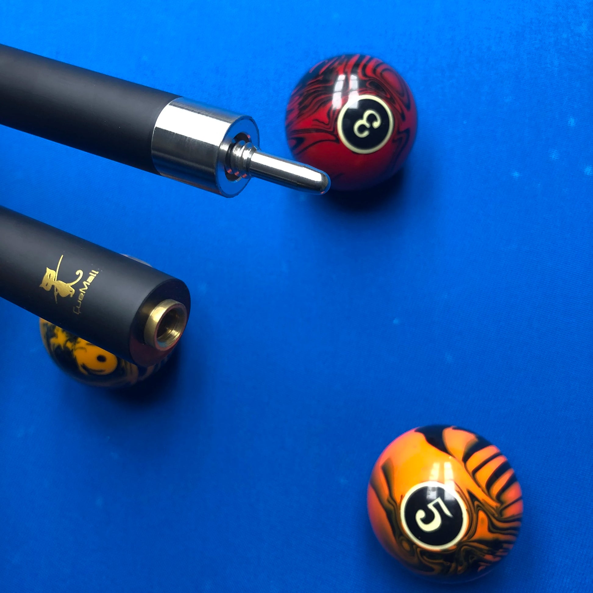 Two pool cues with decorative ends on a blue felt background