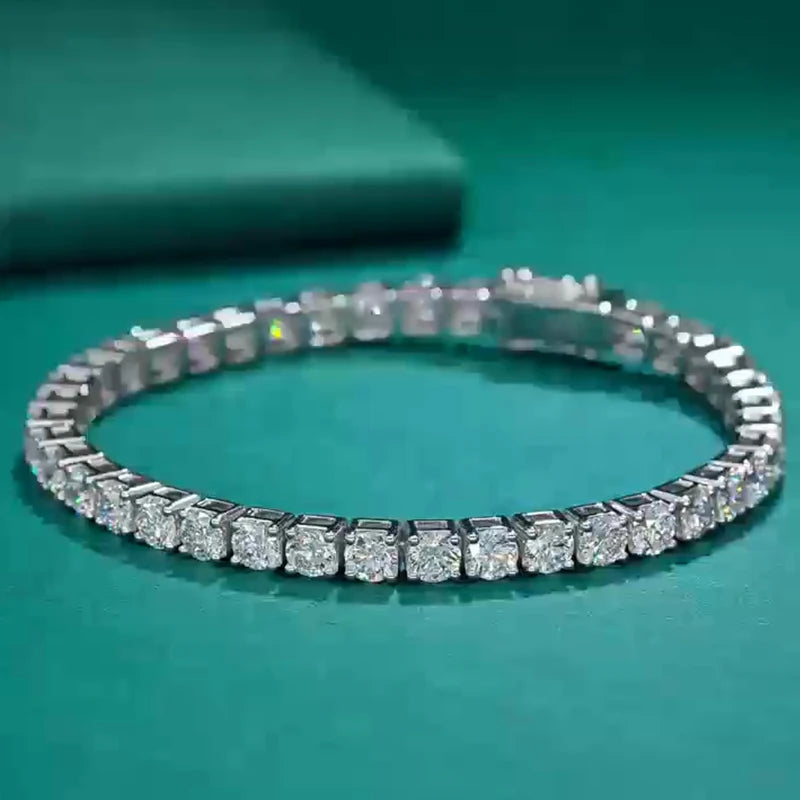 Silver bracelet with clear stones on a teal background