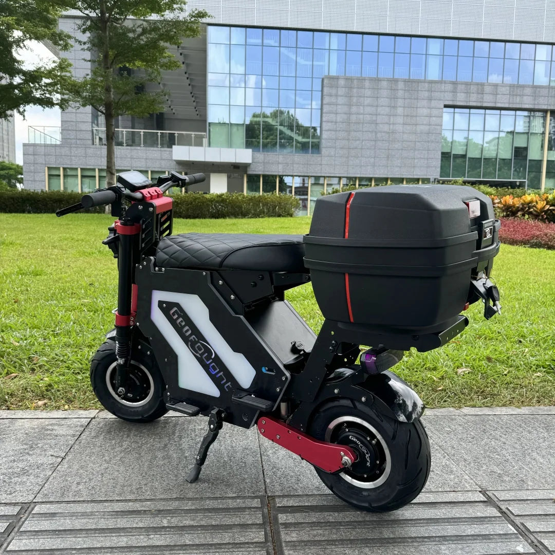 Electric scooter with a black storage box on a sidewalk in an urban setting