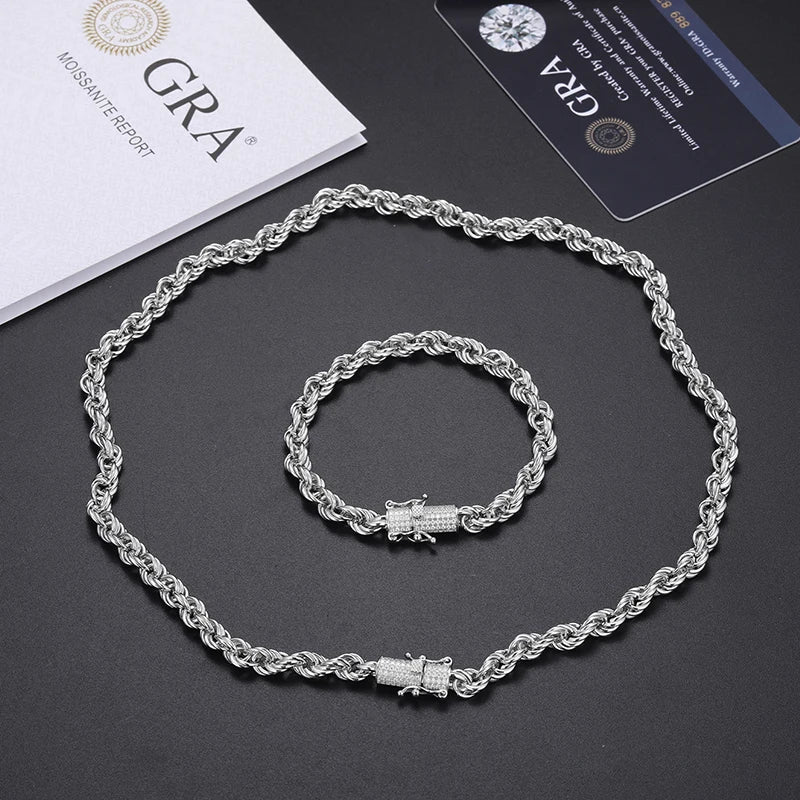 Silver necklace and bracelet set on a dark surface with GRA branding.