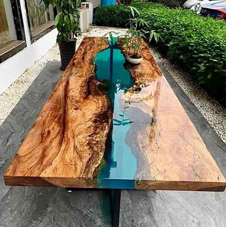 Wooden table with a blue resin river in an outdoor setting