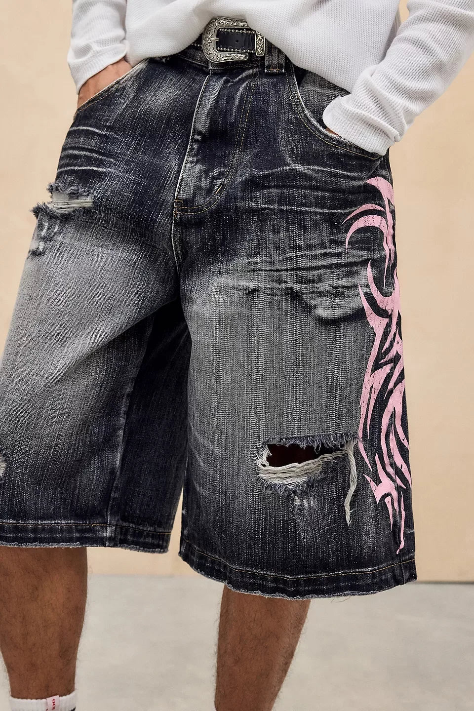 Denim shorts with pink tribal design on a beige background