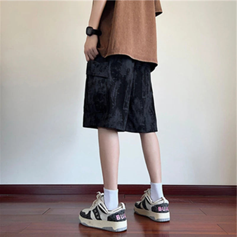 Person wearing black shorts and white sneakers in a minimal indoor setting