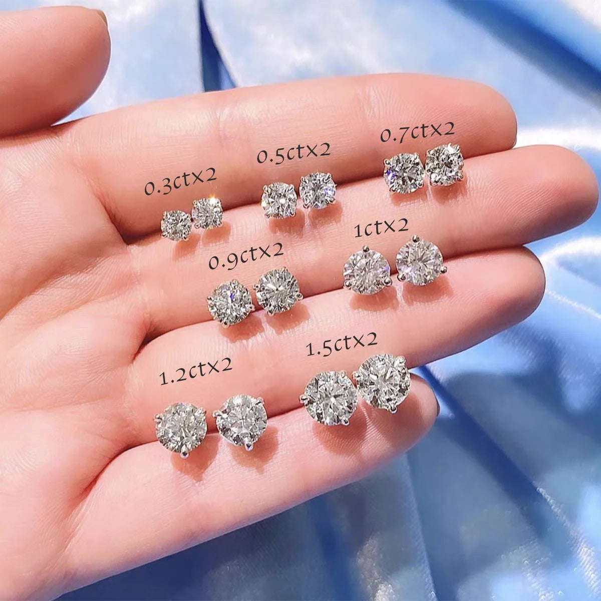 Diamond earrings of various sizes held in a hand with measurements displayed.