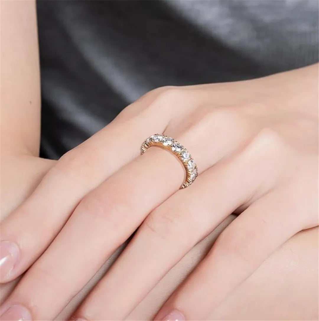 Close-up of a hand wearing a diamond ring with a neutral background