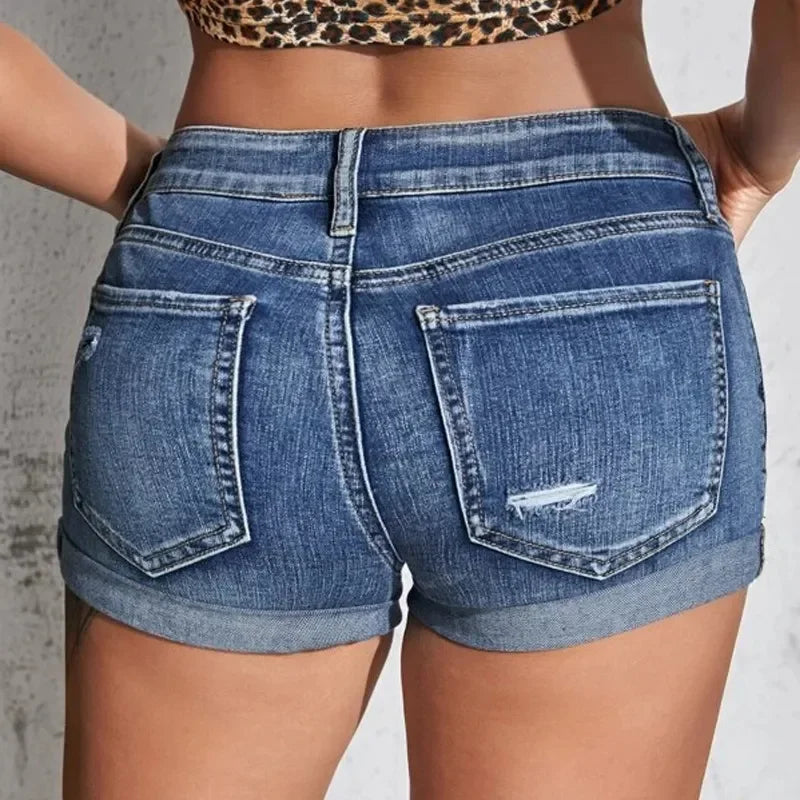 Person wearing blue denim shorts with a neutral background