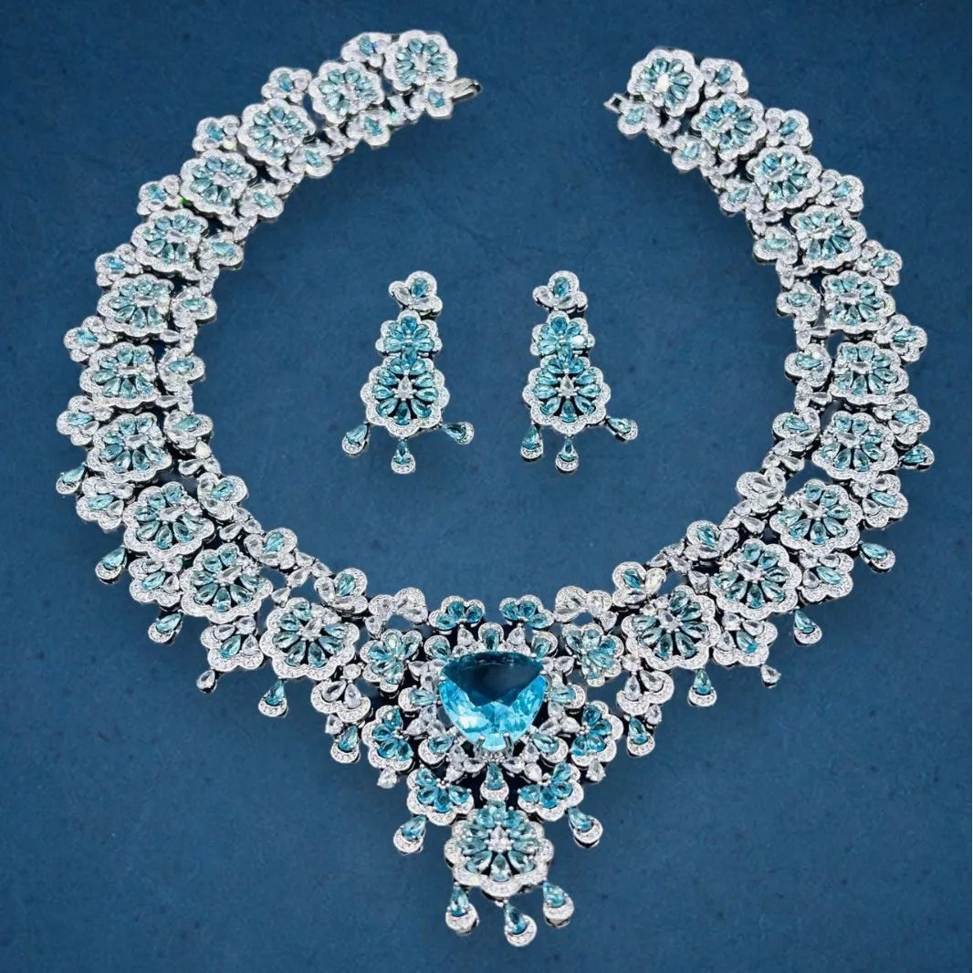 Luxury jewelry set with necklace and earrings on a blue background