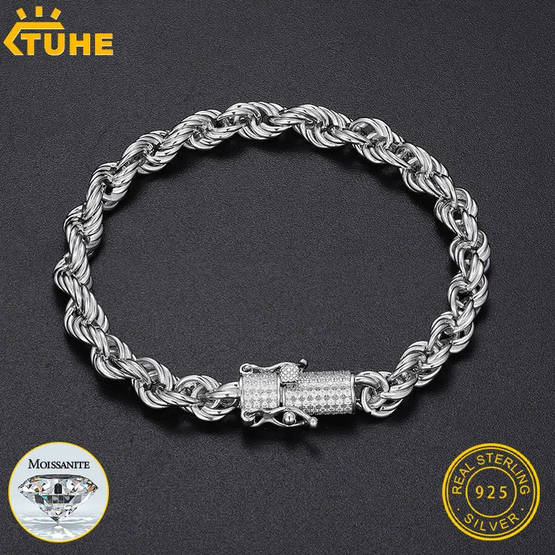 Silver chain bracelet with a diamond clasp on a dark background, featuring TUHE branding.