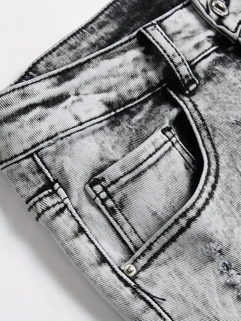 Close-up of a gray acid-wash denim pocket with stitching details.