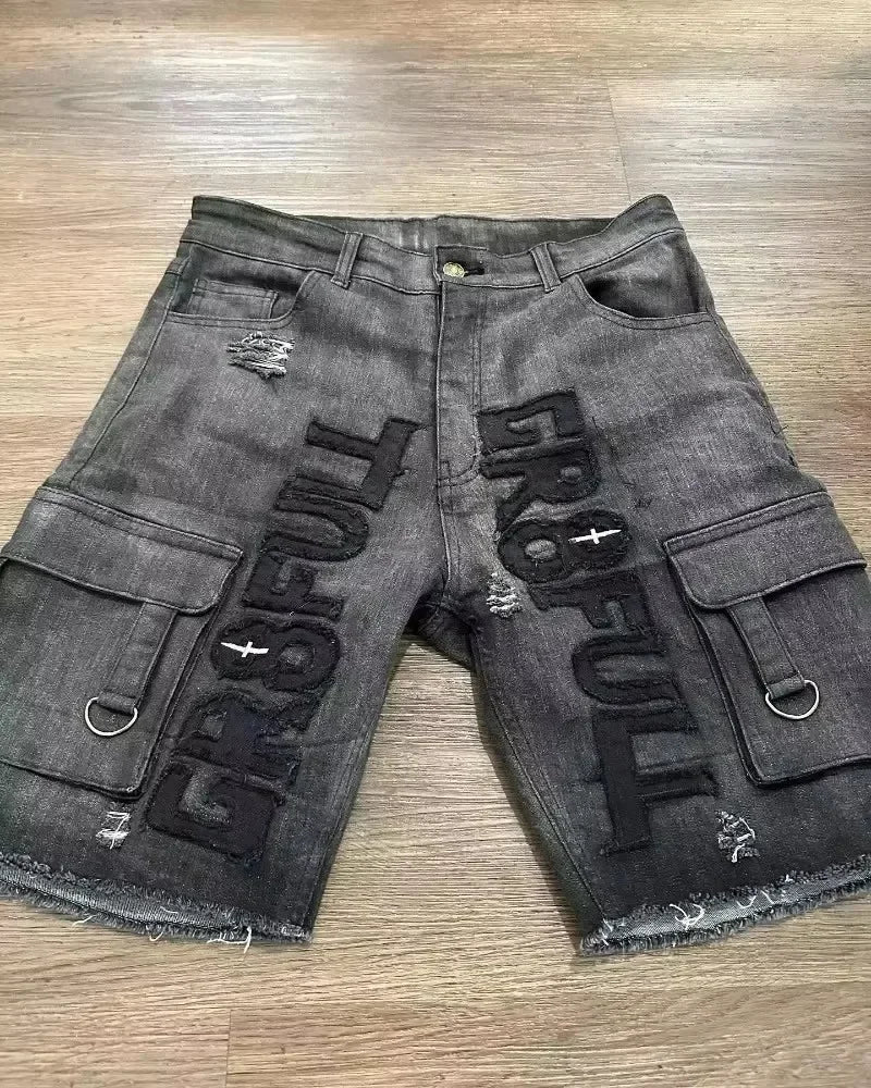 Black denim shorts with 'GRO FULL' branding on a wooden floor.