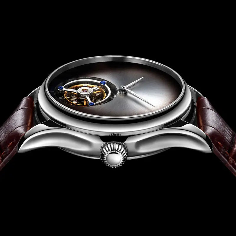 A luxury wristwatch with a polished silver-tone case, featuring a visible tourbillon movement through a dark gradient dial and a brown leather strap, set against a solid black background.