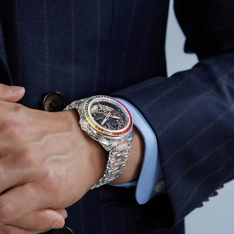 Close-up of a person wearing a silver watch with a colorful face on a blue background