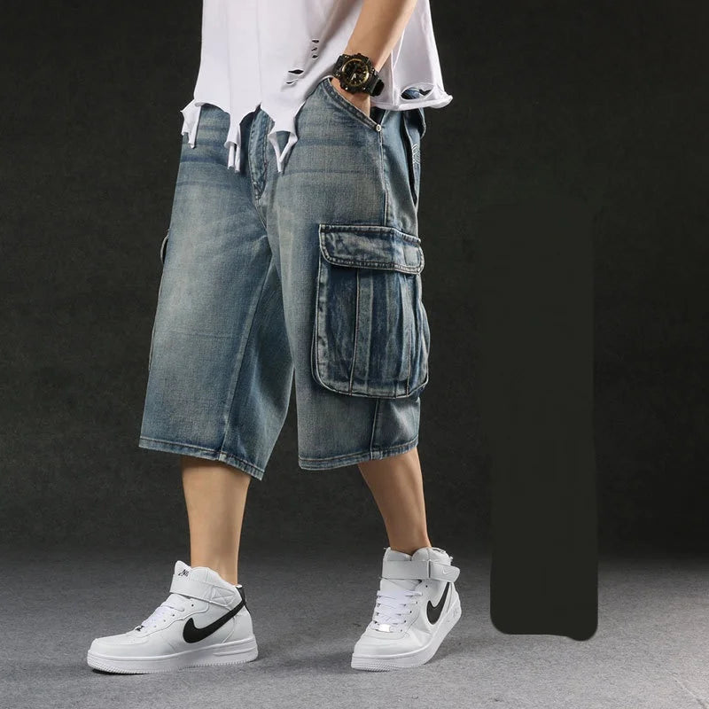 Person wearing blue denim cargo shorts and white sneakers on a dark background