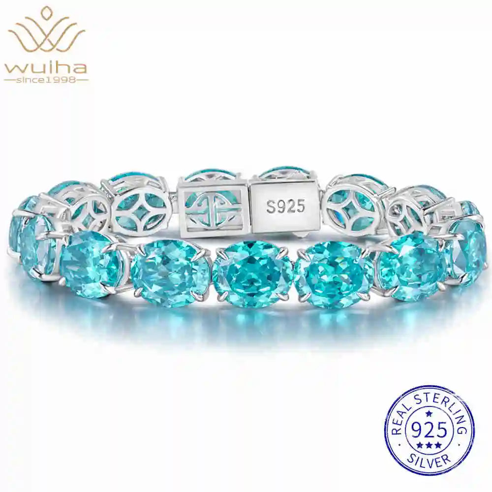 A sterling silver bracelet featuring round-cut light blue gemstones, with a central clasp engraved 'S925'. The brand logo 'wulha' is visible in the top left, and a 'REAL STERLING 925 SILVER' badge is in the bottom right.