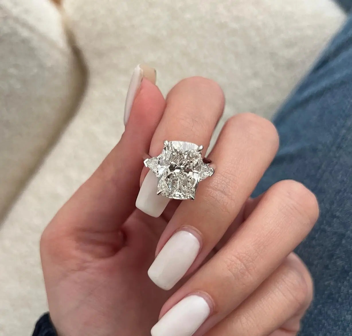 Diamond ring on a finger with a neutral background