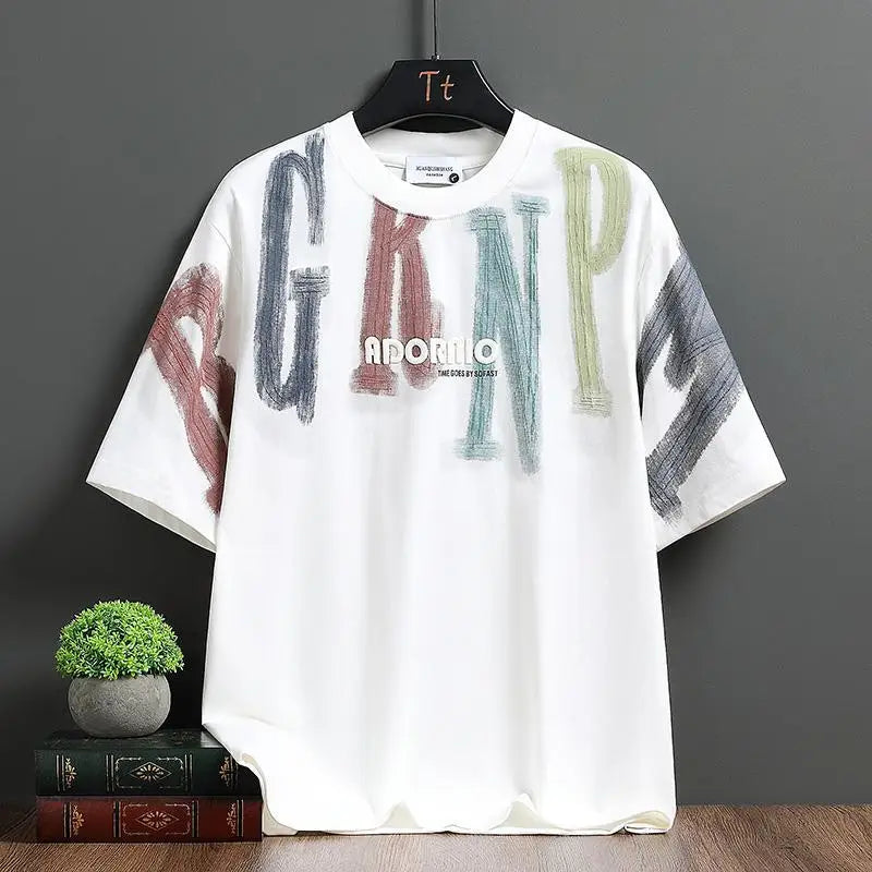 White t-shirt with colorful letters and 'Adormir' branding on a hanger against a gray background.