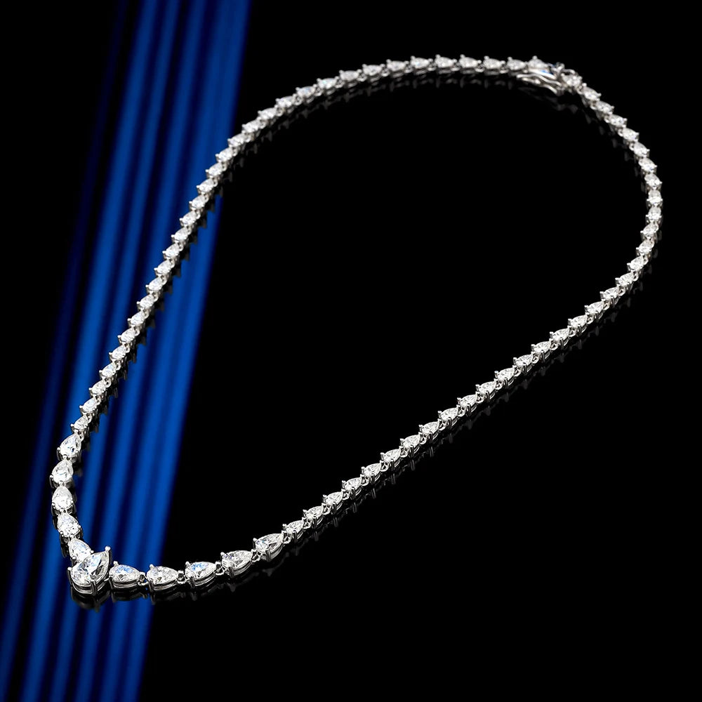 Diamond necklace on a black background with blue draped fabric