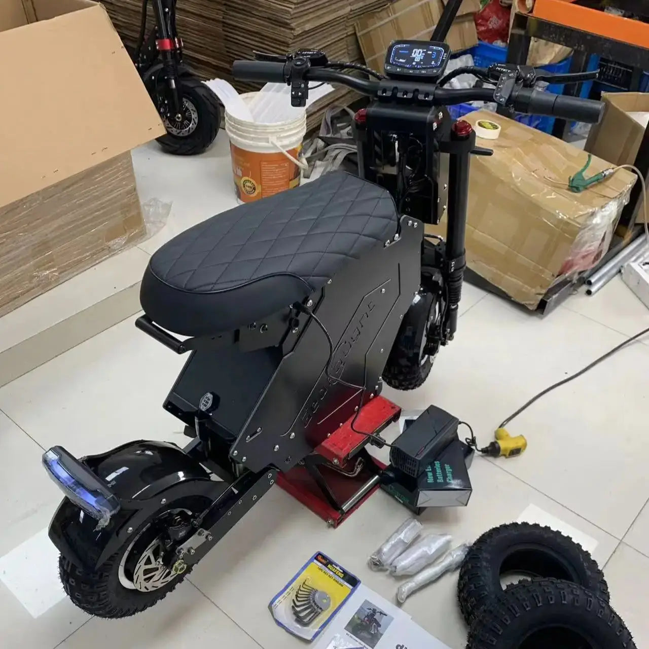 Black electric scooter with accessories on a tiled floor