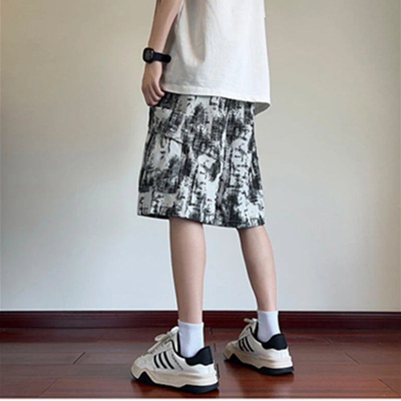 Person wearing a patterned skirt and sneakers on a plain background