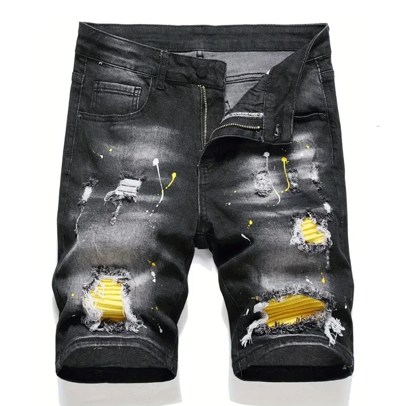 Black distressed denim shorts with yellow accents on a white background