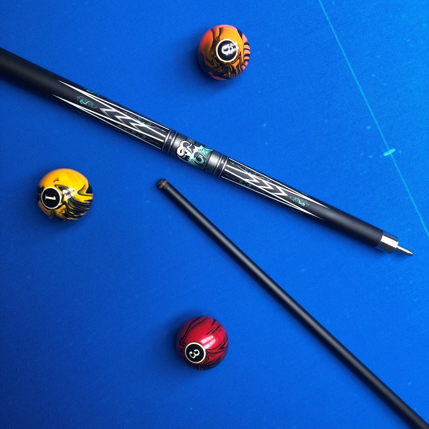 Pool cue and balls on a blue felt surface