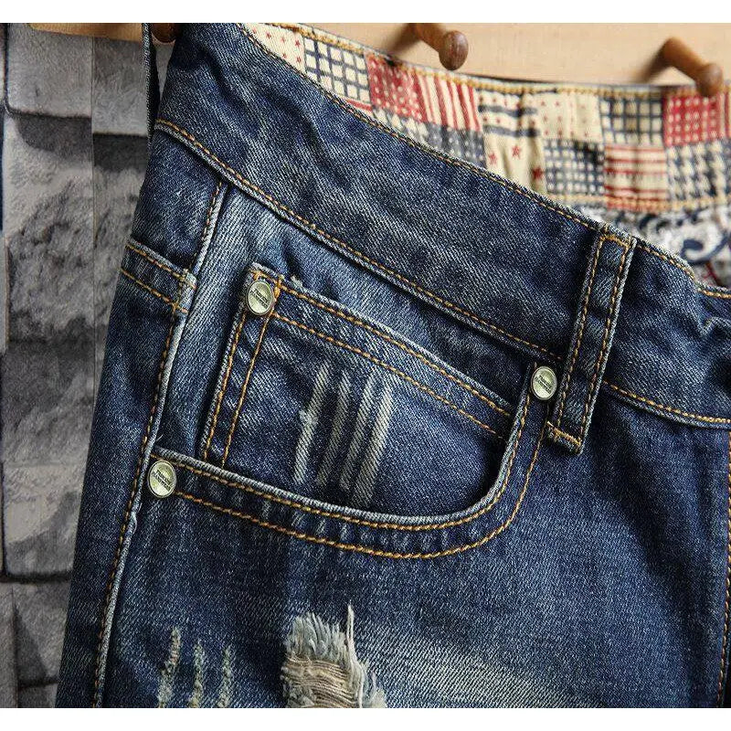 Close-up of blue jeans with a plaid shirt underneath