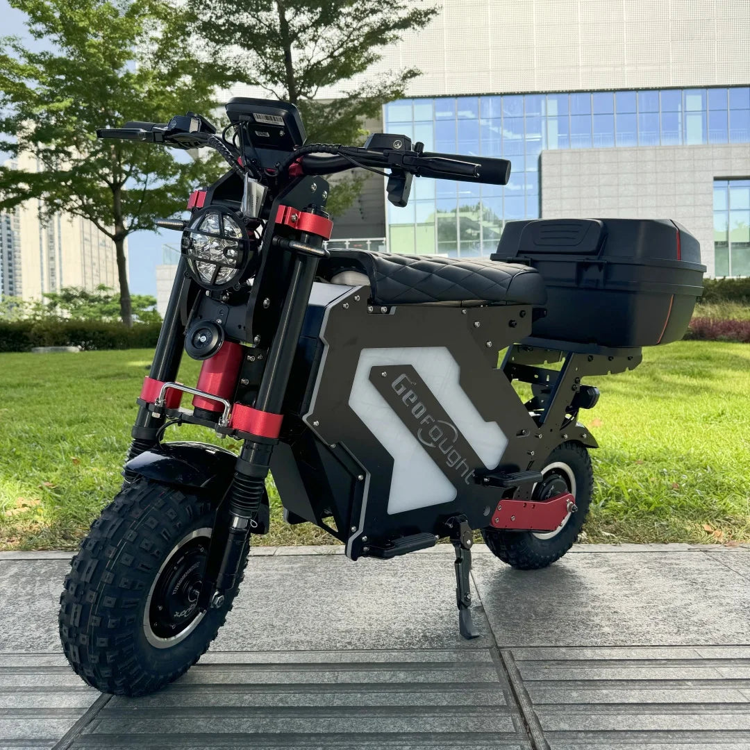 Black electric scooter with red accents on a wooden platform with greenery and a building in the background